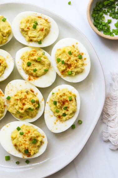 avocado deviled eggs served on a white plate.