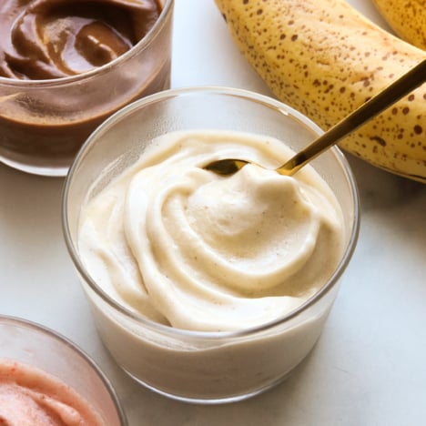 banana ice cream with a spoon inside a glass bowl.