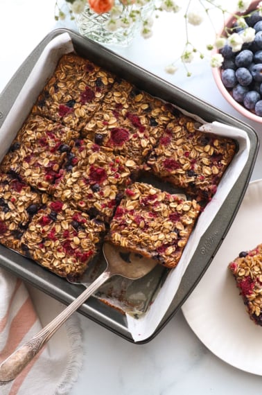 berry baked oatmeal sliced in a square pan.