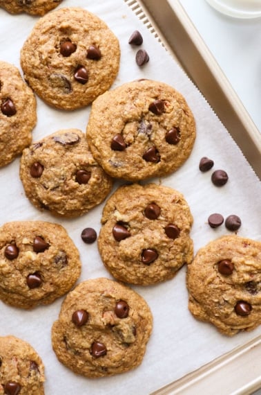 several buckwheat chocolate chip cookies arranged on a lined baking sheet.