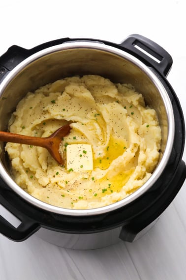 Mashed Potatoes topped with butter and chives in the Instant Pot.