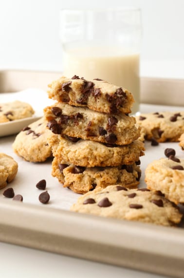 Paleo chocolate chip cookies stacked on a baking sheet.