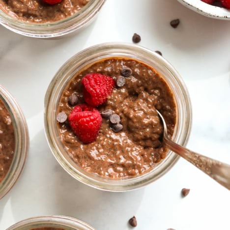 chocolate chia pudding topped with raspberries and chocolate chips.