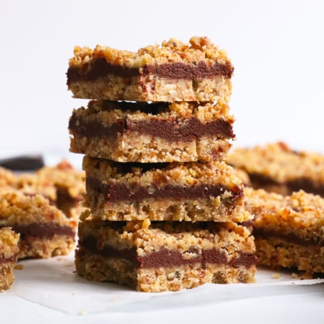 chocolate walnut bars stacked on parchment paper.