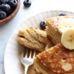 a fork full of coconut flour pancakes after cutting into a stack.