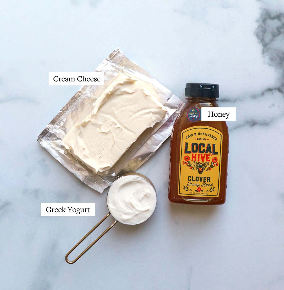 cream cheese, honey, and greek yogurt labeled on a white surface.