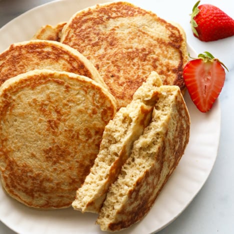 pancake ripped in half on a plate to show the fluffy texture.