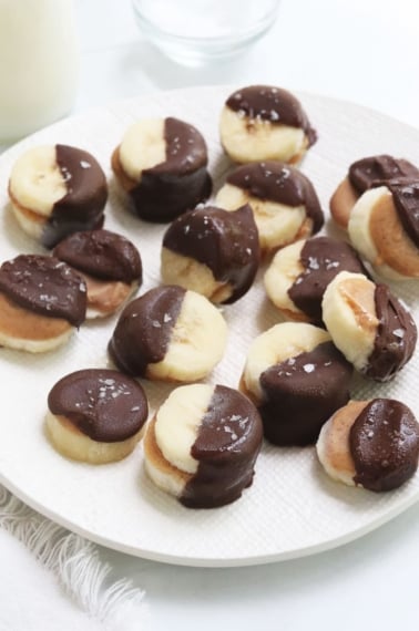 frozen banana bites on white plate.