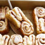 gluten free bunny cinnamon roll lifted up on a spatula.