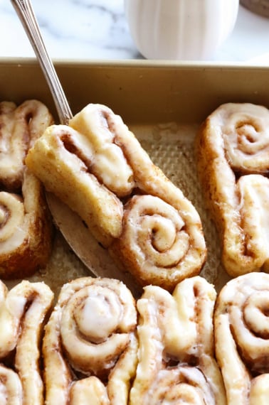 gluten free bunny cinnamon roll lifted up on a spatula.