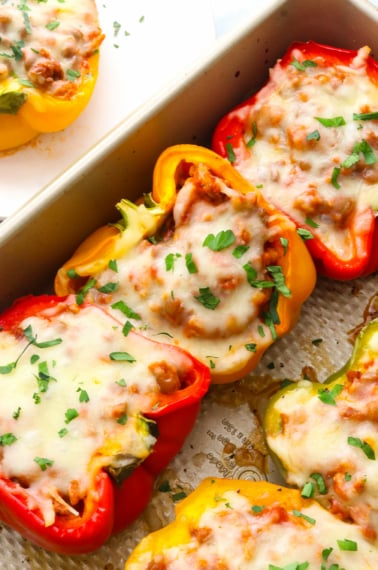 ground turkey stuffed peppers topped with mozzarella and parsley.