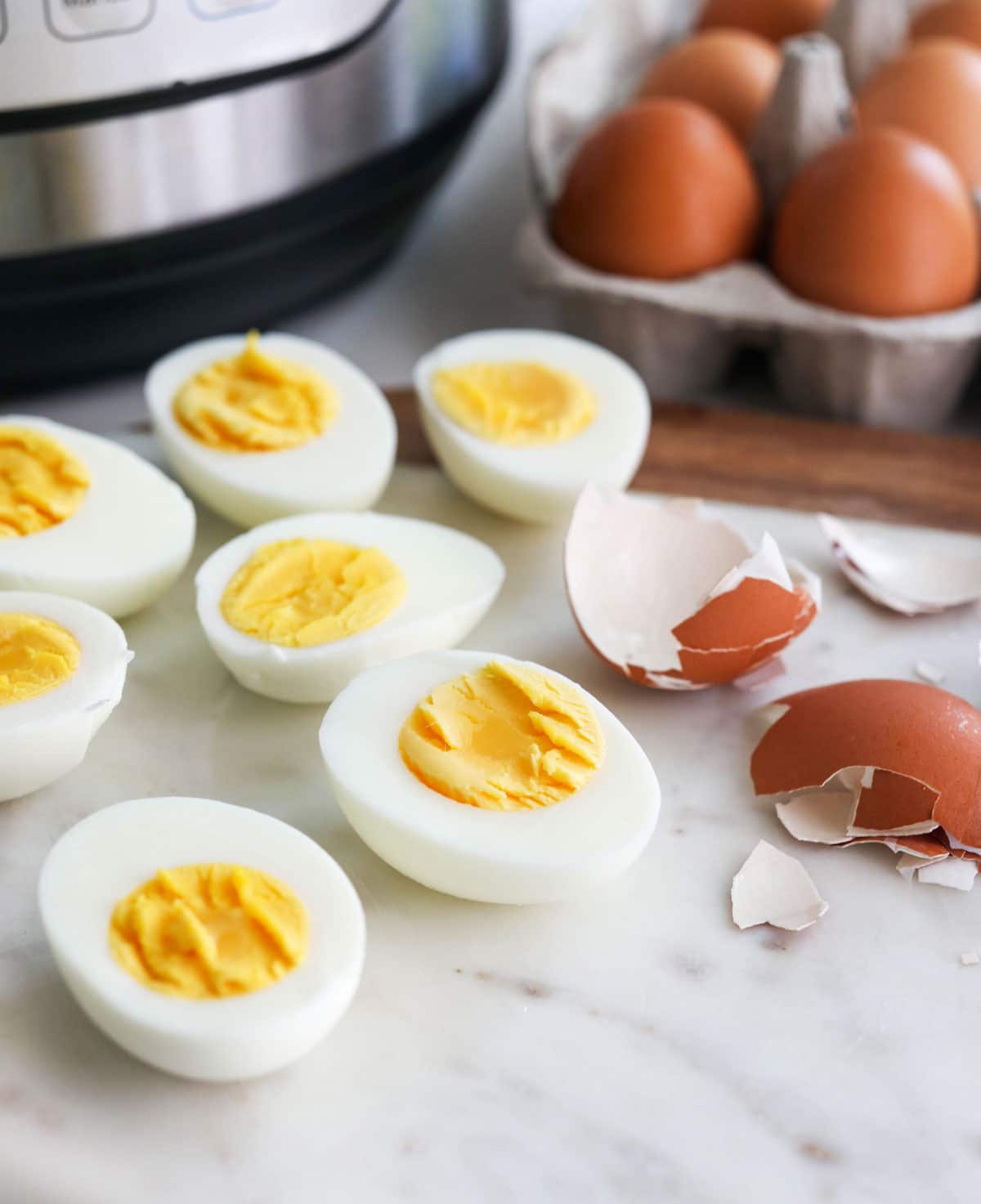 hard boiled eggs cut open with the peeled shell nearby