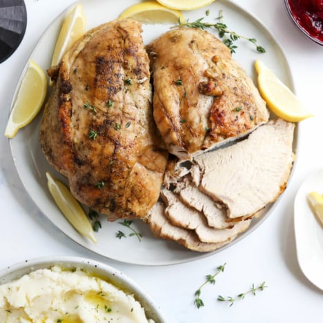 Cooked turkey breast on a white platter