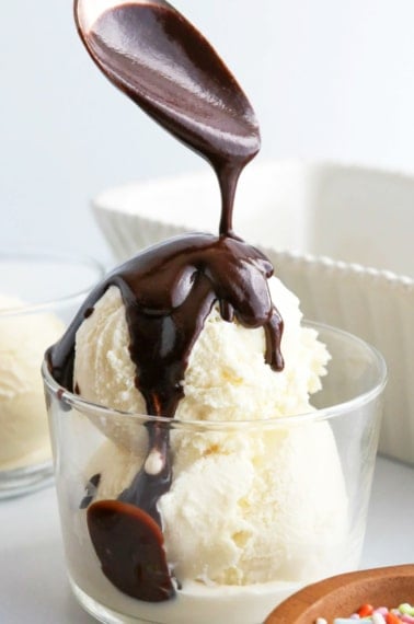 homemade magic shell recipe poured over ice cream with a spoon.