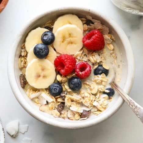 close up of muesli in a bowl topped with berries.