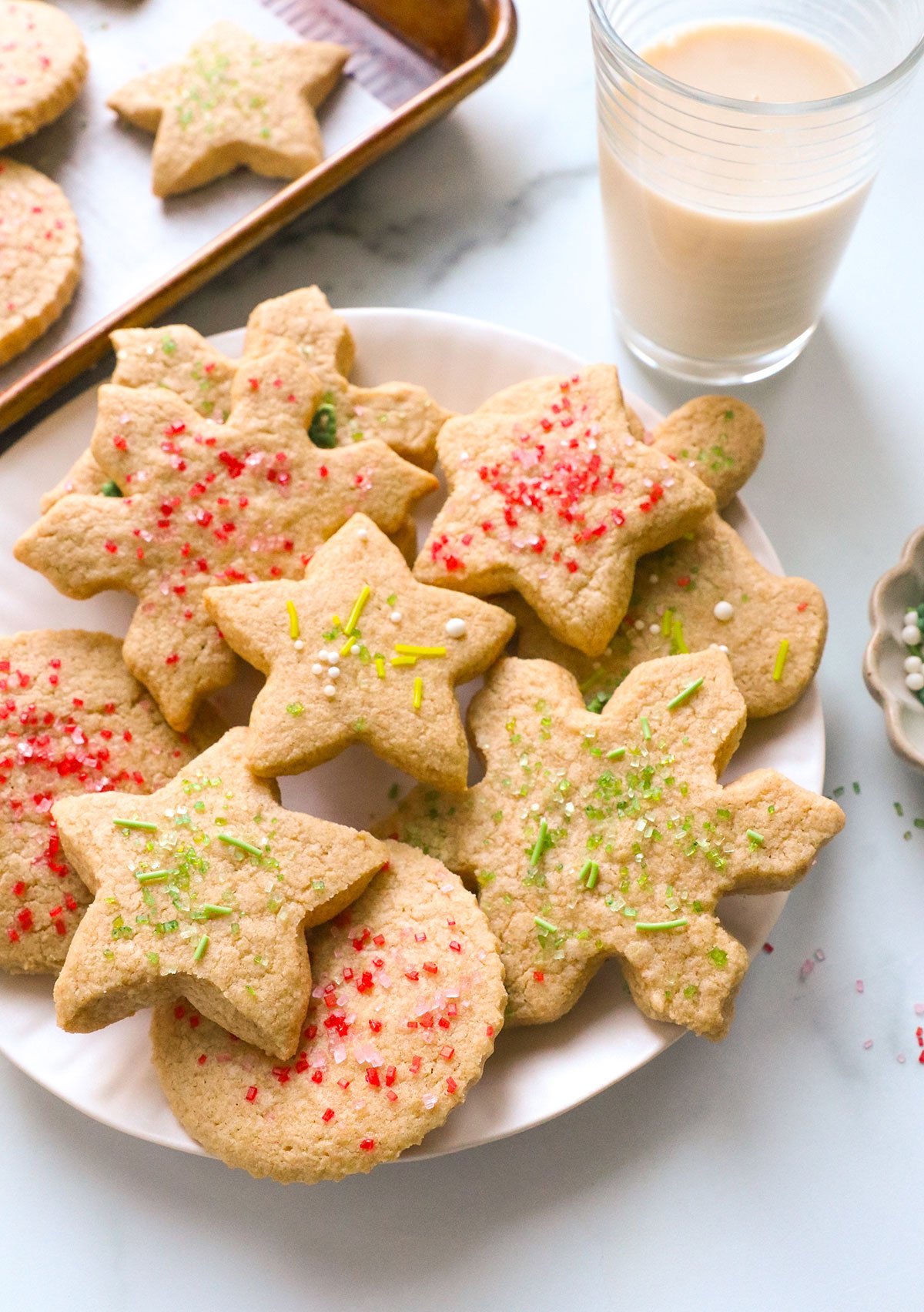 oat flour sugar cookies on a white plate topped with sprinkles.