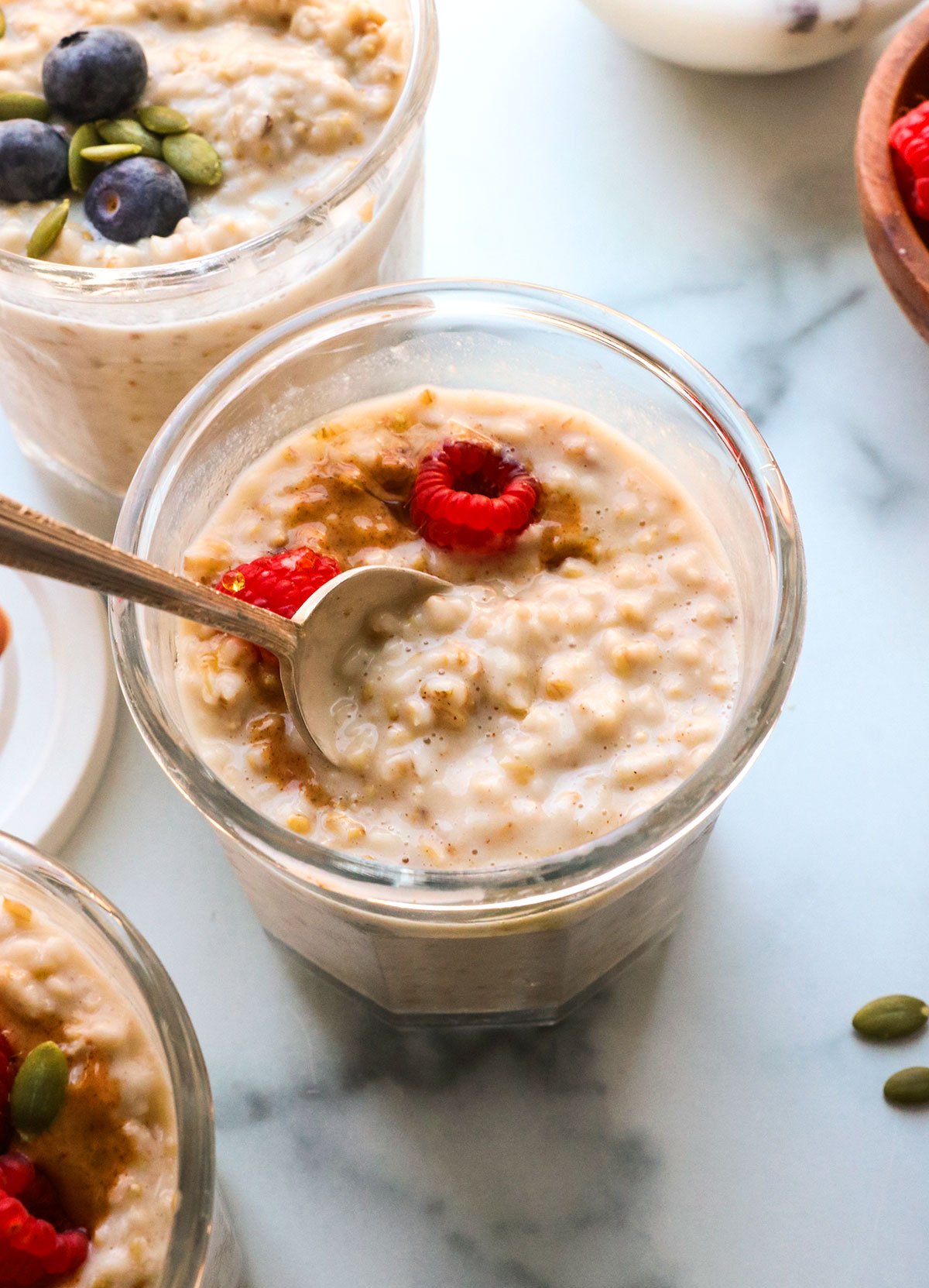 overnight steel cut oats topped with berries in a meal prep jar. 