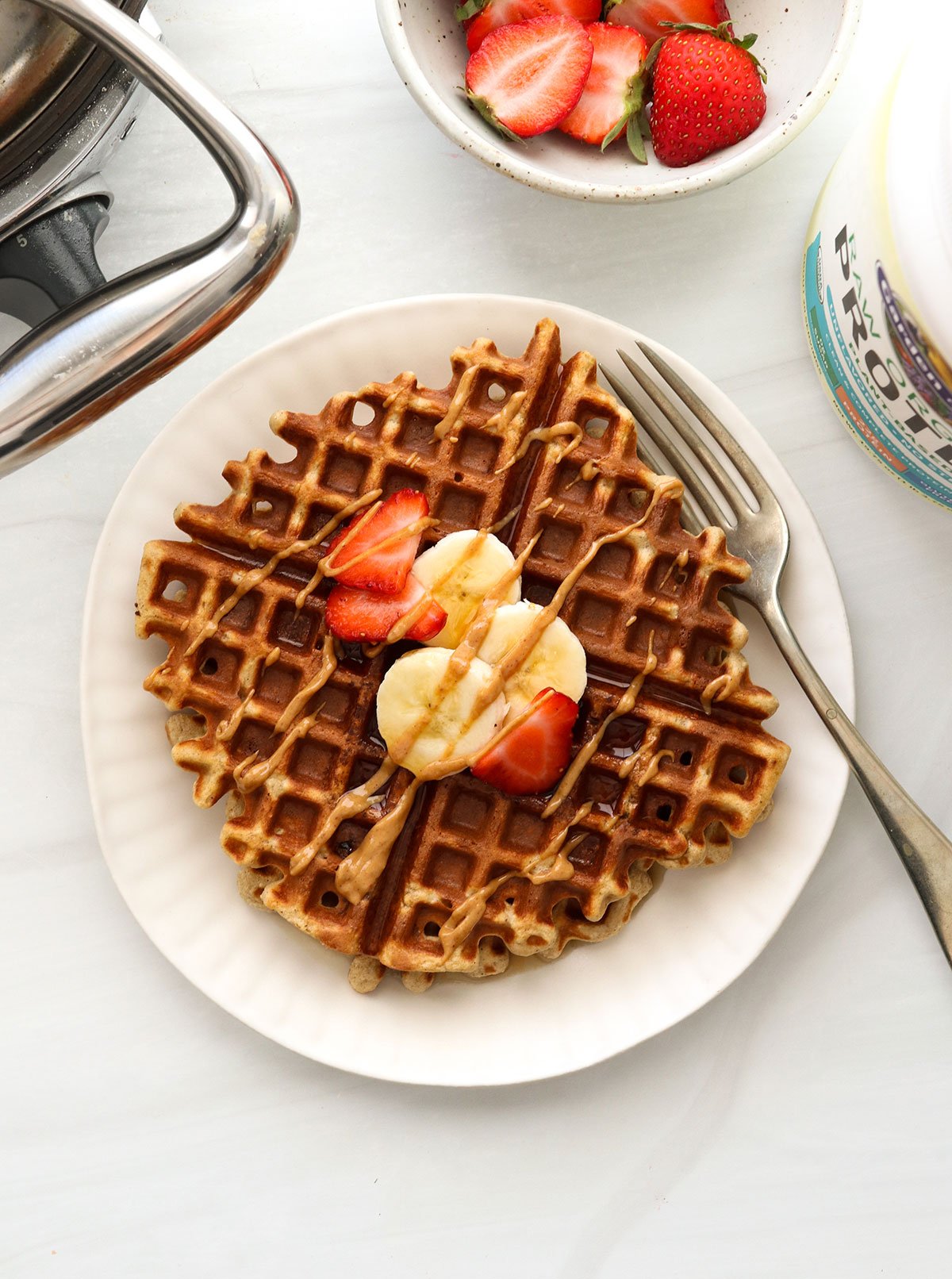 protein waffle topped with fruit and peanut butter.