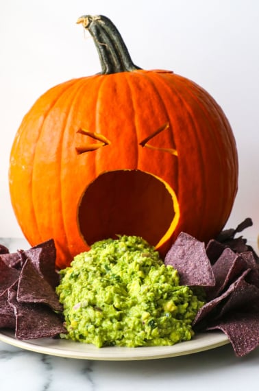 puking pumpkin guacamole appetizer with blue corn tortilla chips