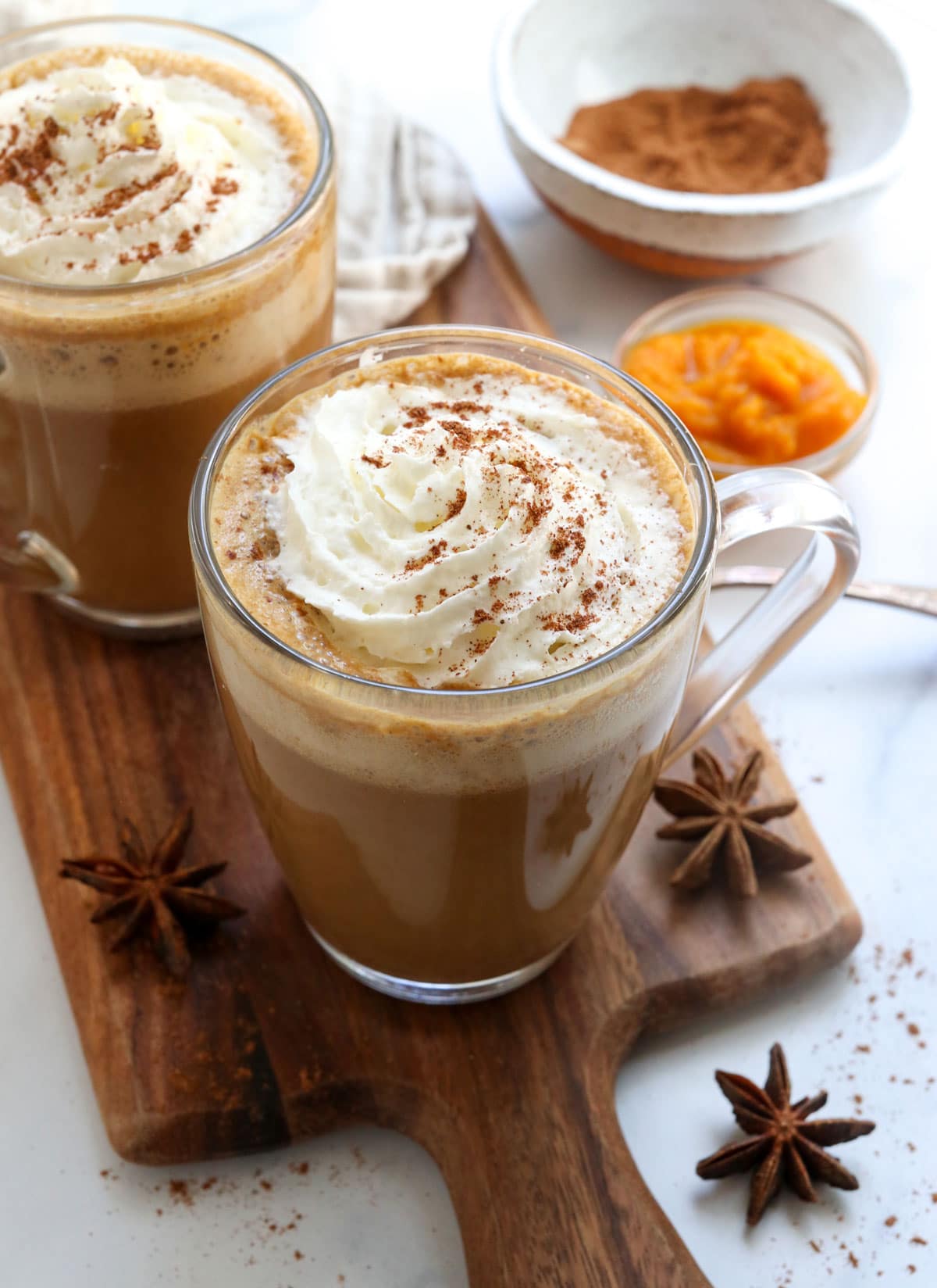 pumpkin spice latte in glass with whipped cream on top