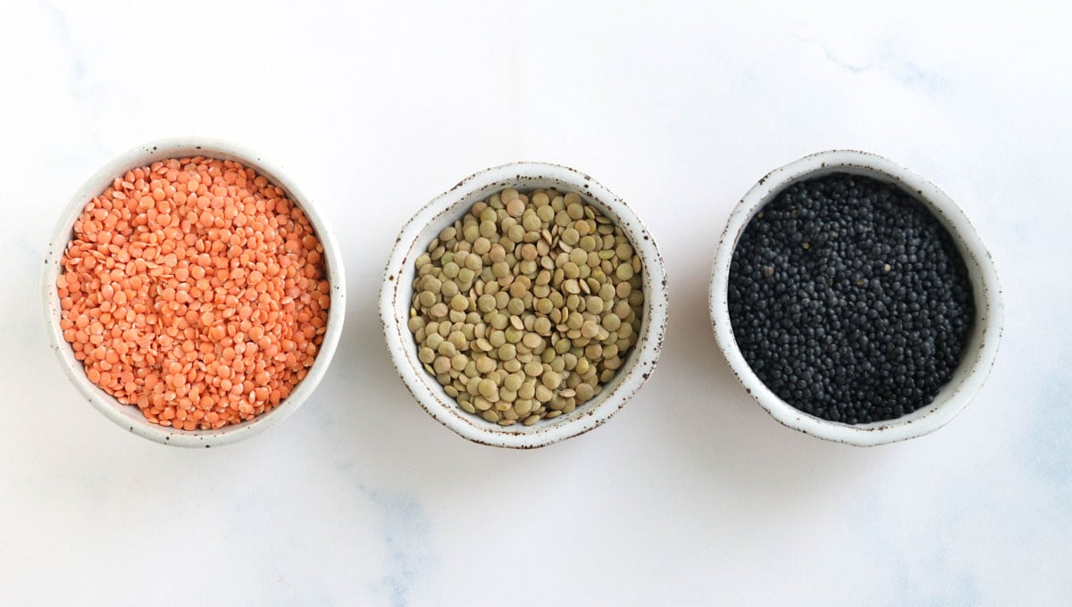 red green and black lentils in white bowls