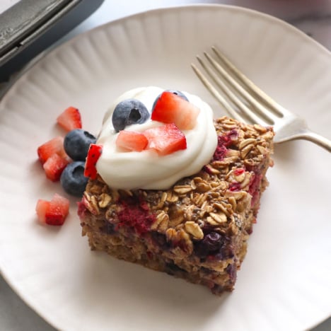 slice of berry baked oatmeal topped with greek yogurt and berries.