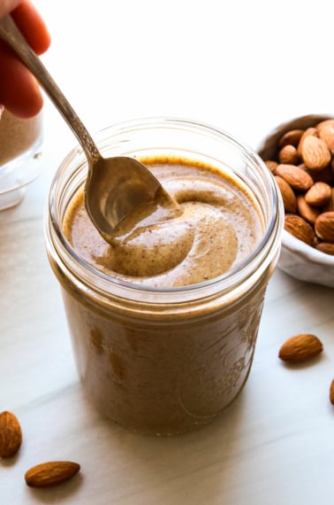 homemade almond butter stirred with a spoon.