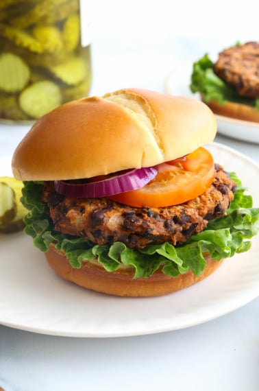 sweet potato black bean burger served on a bun with lettuce and tomato.