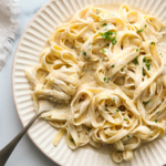 vegan alfredo sauce over noodles and twirled on a fork.