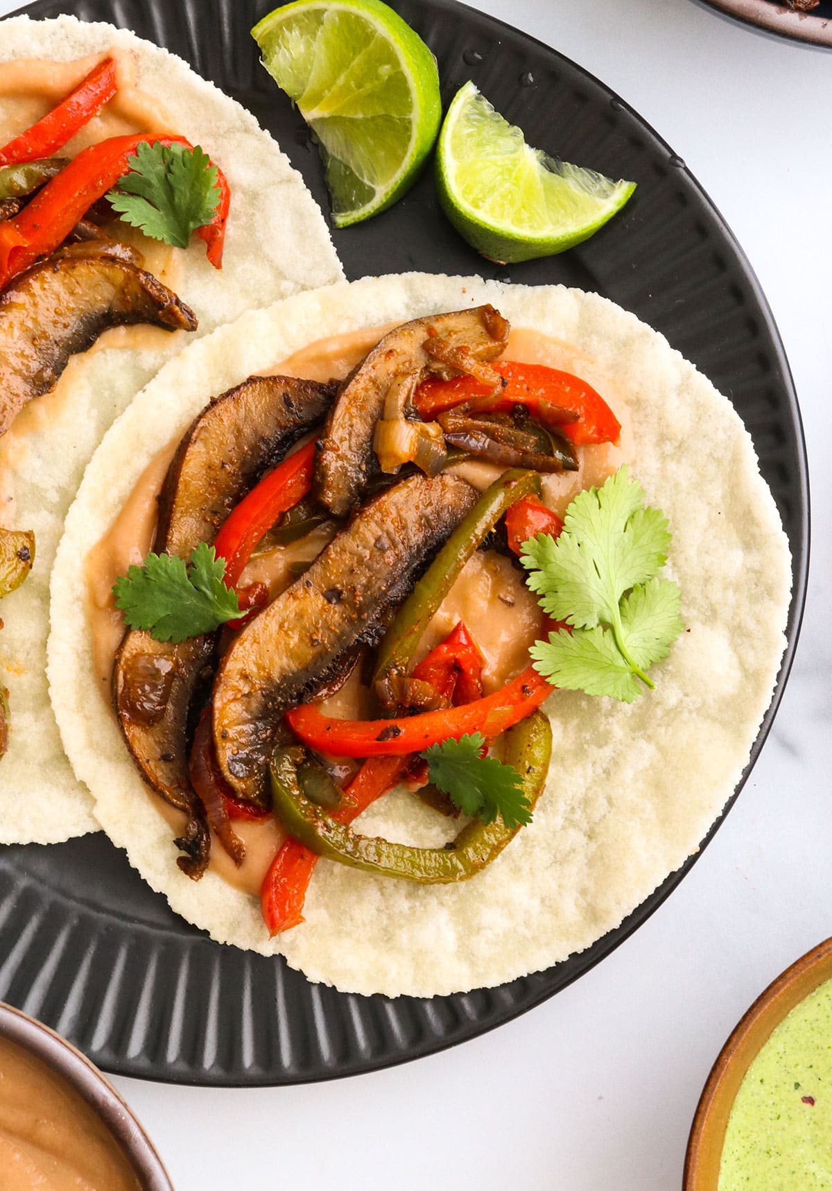 cooked fajita veggies added to a tortilla with bean dip.