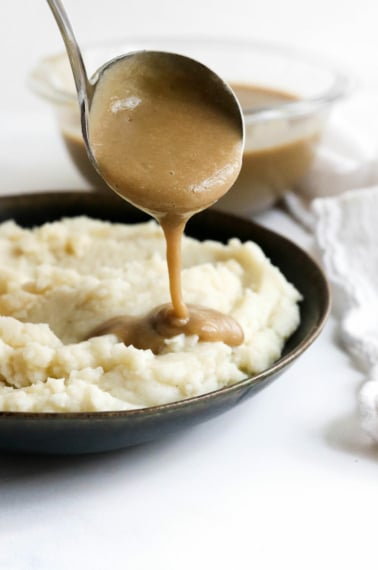 vegan gravy ladled over potatoes