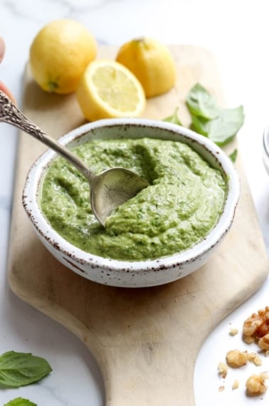 vegan pesto with spoon and lemons