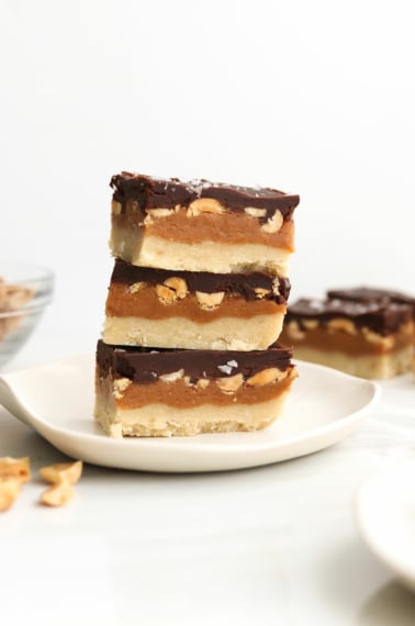 vegan snickers bars stacked on white plate.