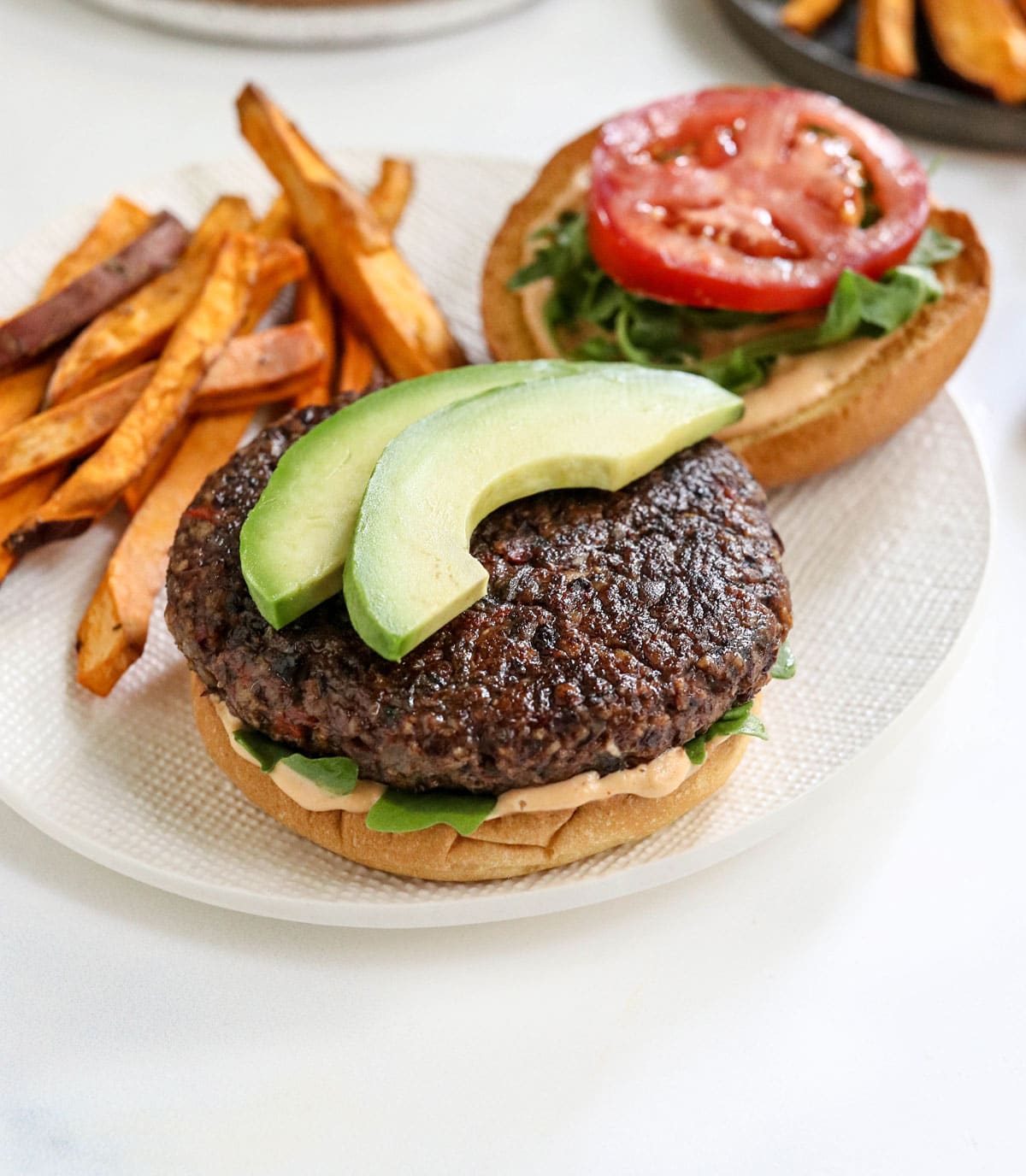 veggie burger topped with sliced avocado